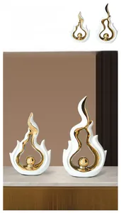 Close-up of white and gold ceramic flame sculptures with a luxury metallic finish