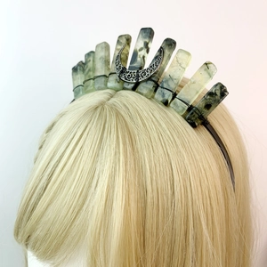 Detail of green natural crystal crown with carved metal triple moon on a model