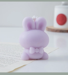 Detailed close-up of a purple bunny scented candle with a cute bow design for home decor