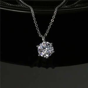 Macro view of 2-carat six-prong round moissanite pendant on silver chain necklace