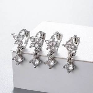 Set of four silver cartilage hoop earrings with star, flower, clover and butterfly charms