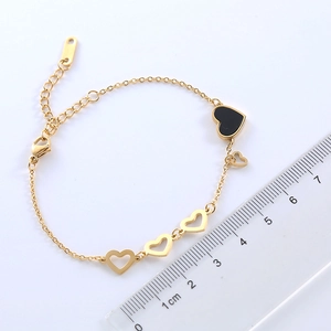 Elegant gold hollow heart bracelet with black shell pendant and measuring ruler size detail