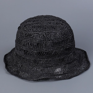 Detailed view of the hollow crochet weave pattern on a black handmade straw sun hat