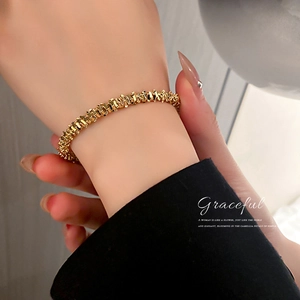 Minimalist gold textured geometric cuff bracelet for women shown on a model's wrist