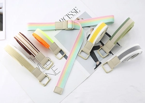 Detail of colorful striped canvas belts with double ring buckles on a fashion magazine