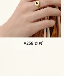 Vue détaillée d'une bague dorée minimaliste avec cœur en émail noir portée à la main