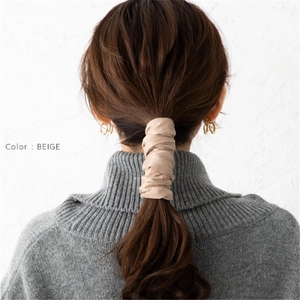 Close-up of beige velvet hair tie wire wrap styling on a woman's low ponytail