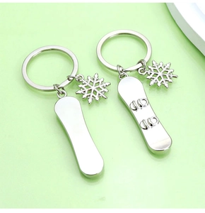 Detailed view of silver metal keychain with miniature skis and snowflake charms