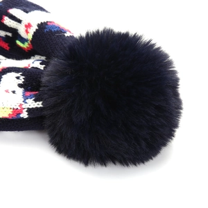 Vista dettagliata di un soffice pompon di pelliccia sintetica blu su un cappello in maglia