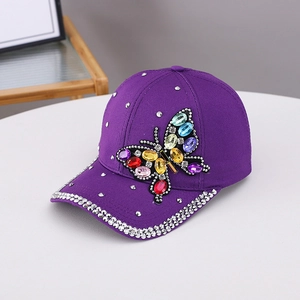 Detailed shot of purple cotton baseball cap with colorful rhinestone butterfly and brim