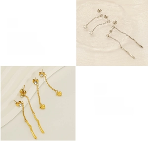 Detail of polished tassel earrings with zircon studs and delicate heart charms