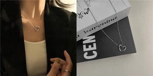 Detail view of silver heart pendant necklace shown on model and luxury background