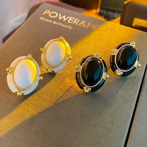 Vintage oval enamel stud earrings in cream and black with gold beaded metal edges