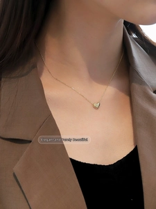Close-up of a 925 sterling silver heart pendant necklace in 18K gold finish on a model