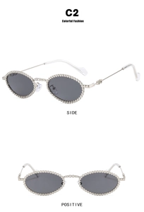 Detail view of oval sunglasses featuring silver metal frames and sparkling crystal rhinestones