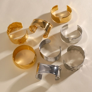 Macro detail of various gold and silver minimalist textured open bangles and bracelets