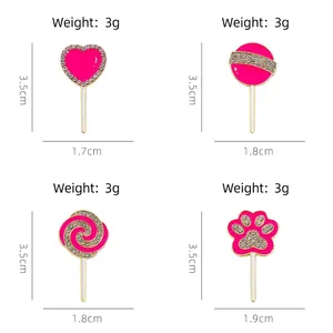 Pink lollipop brooches with cat paw and heart shapes featuring rhinestones and gold metal