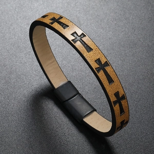 Close-up of brown braided leather bracelet with black cross print and magnetic buckle