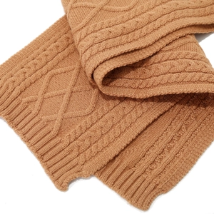 Detail of caramel cable knit scarf showing thick wool texture and ribbed edges