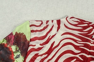 Dettaglio del tessuto a rete zebrato e delle cuciture con stampe di paesaggi colorati