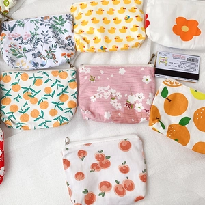 Detailed top view of various floral and fruit print canvas mini coin pouches with zippers