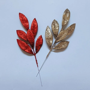 Dettaglio di foglie di pino con glitter rosso e oro per decorazioni di alberi di Natale