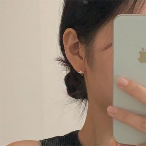 Minimalist 925 sterling silver star stud earrings shown in a lifestyle side view