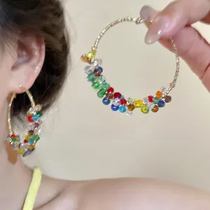 Détail de perles de cristal colorées sur des créoles dorées de style bohème