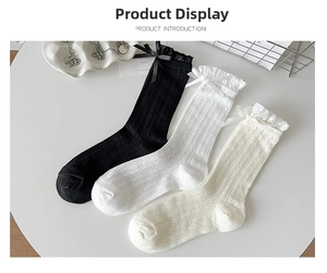Detail of cotton socks with lace trim and bow knot in black, white, and cream colors
