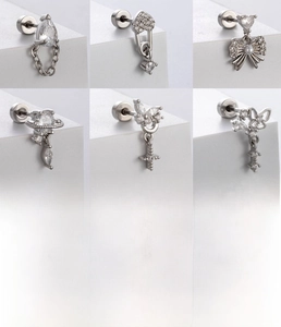 Detailed views of titanium steel piercing studs with heart, bow, and cross designs