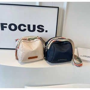 Detail of small nylon crossbody bags with colorful floral pattern woven shoulder straps