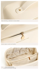 Detailed close-up of cream PU makeup bag featuring gold zippers and multi-compartment interior