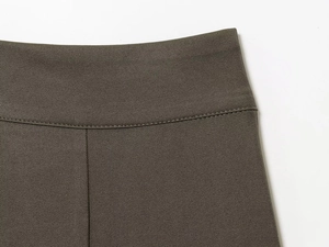 Detail einer olivgrünen Hose mit präzisen Nähten und einer feinen Twill-Baumwollstruktur