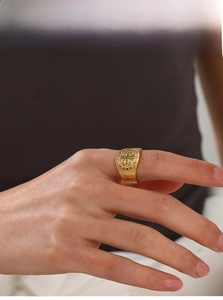 Close-up of gold-plated Saint Benedict religious signet ring with engraved detail