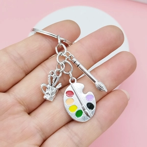 Detailed close-up of a silver artist keychain with paint palette and brush charms