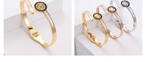 Dettaglio del bracciale a quadrifoglio dorato con intarsio in cristallo e molla interna