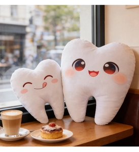 Coussins en peluche en forme de dent avec visages de dessins animés sur table de café