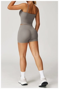 Detail of cross-back straps and seamless lifting shorts on dark gray yoga set
