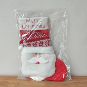 Macro detail of a red knitted Christmas stocking with a 3D Santa Claus figure in a bag