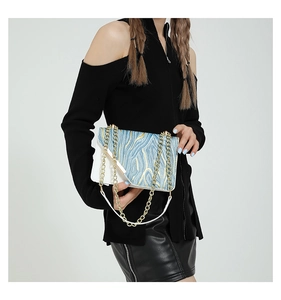 Detail of blue and white stone pattern shoulder bag with a gold chain strap and PU leather