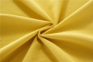 Close-up of yellow washed cotton tablecloth showing soft fabric texture and natural grain