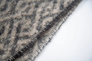 Detailed close-up of dark grey and beige leopard jacquard scarf with premium stitched edges