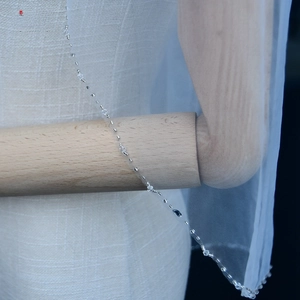 Detailed close-up of white bridal veil featuring delicate handmade crystal beadwork