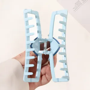 Close-up of light blue hair claw clip with a hollow rectangular design and metal spring