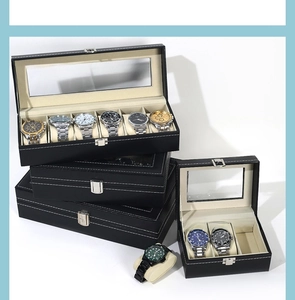 Detail of black leather watch box featuring transparent window and silver metal latch