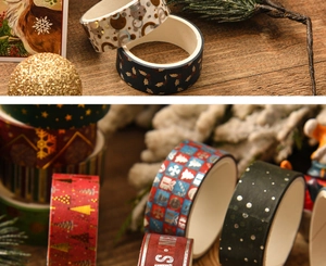 Close-up of Christmas washi tape with gold foil patterns on a festive wooden surface