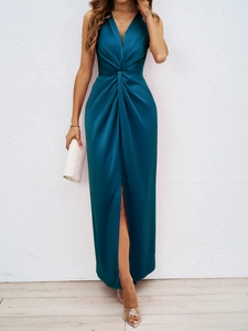 Detail of elegant peacock green satin dress featuring a twisted V-neckline and slit