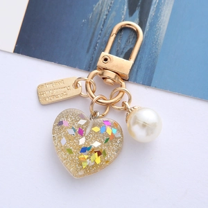 Detailed macro view of heart resin keychain with colorful glitters and a white pearl