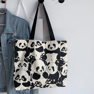 Close-up of cute panda pattern canvas tote bag with black handles and zipper closure