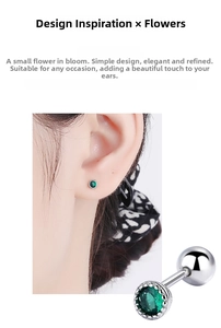 Macro detail of silver stud earrings with a green round gemstone and screw-back closure